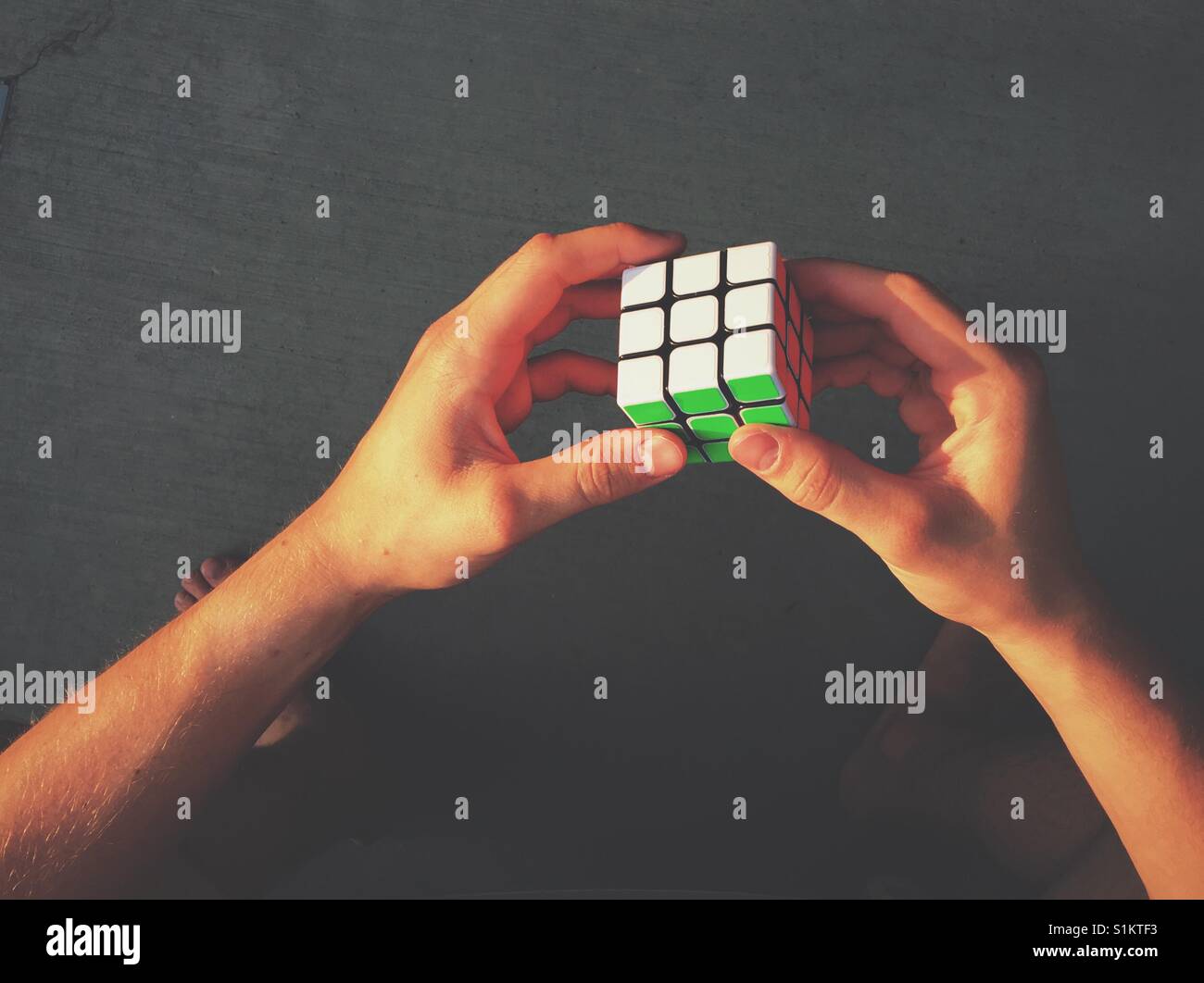 Punto di vista colpo di mani tenendo un cubo di Rubik. Foto Stock
