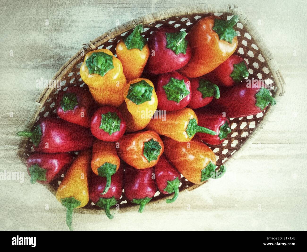 Homegrown organico giallo rosso e arancio peperoni colorati in un cesto su un tavolo di legno. - Immagine stock catturata con smartphone