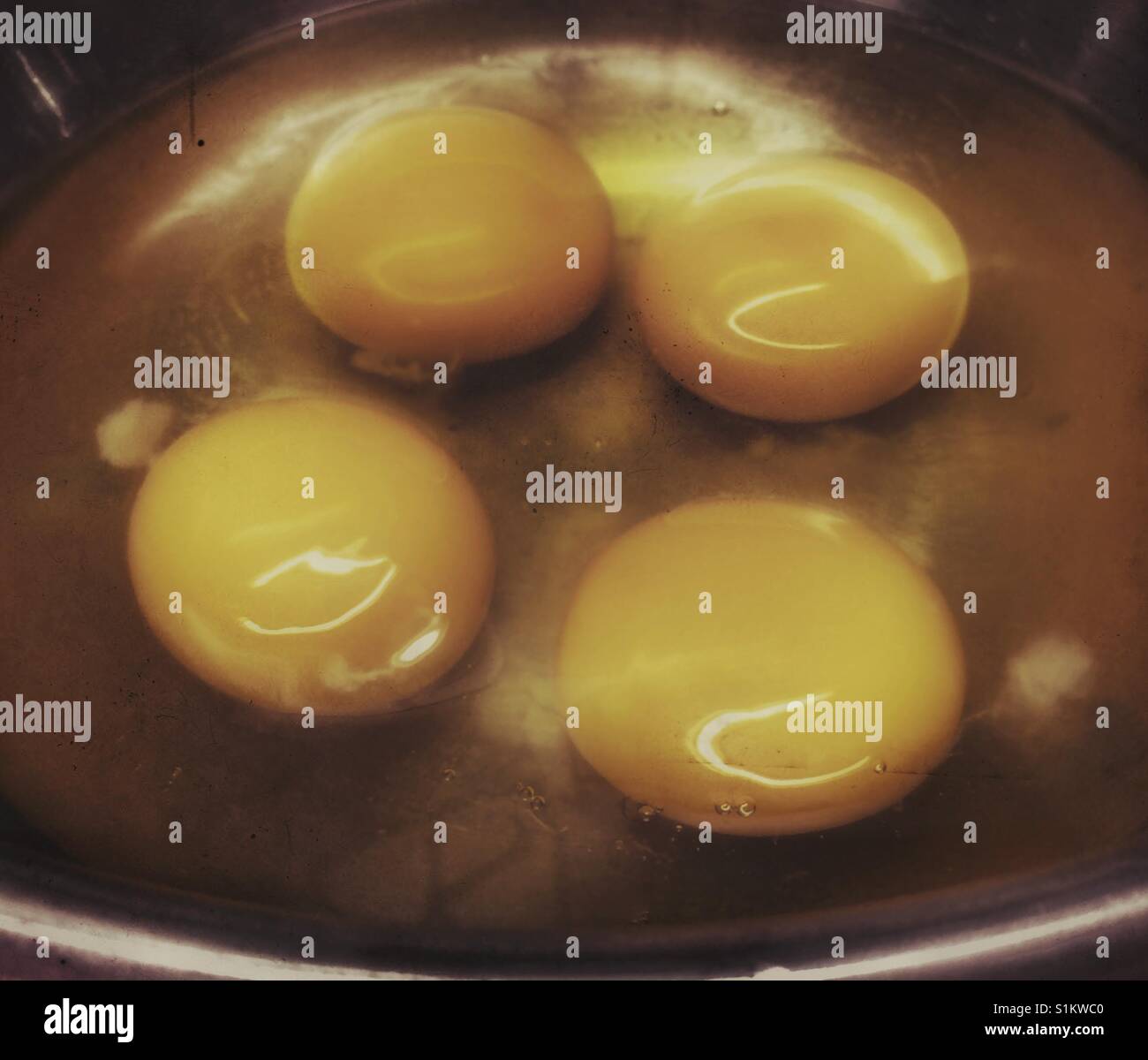 Quattro incrinato uova crude in una ciotola. Foto Stock