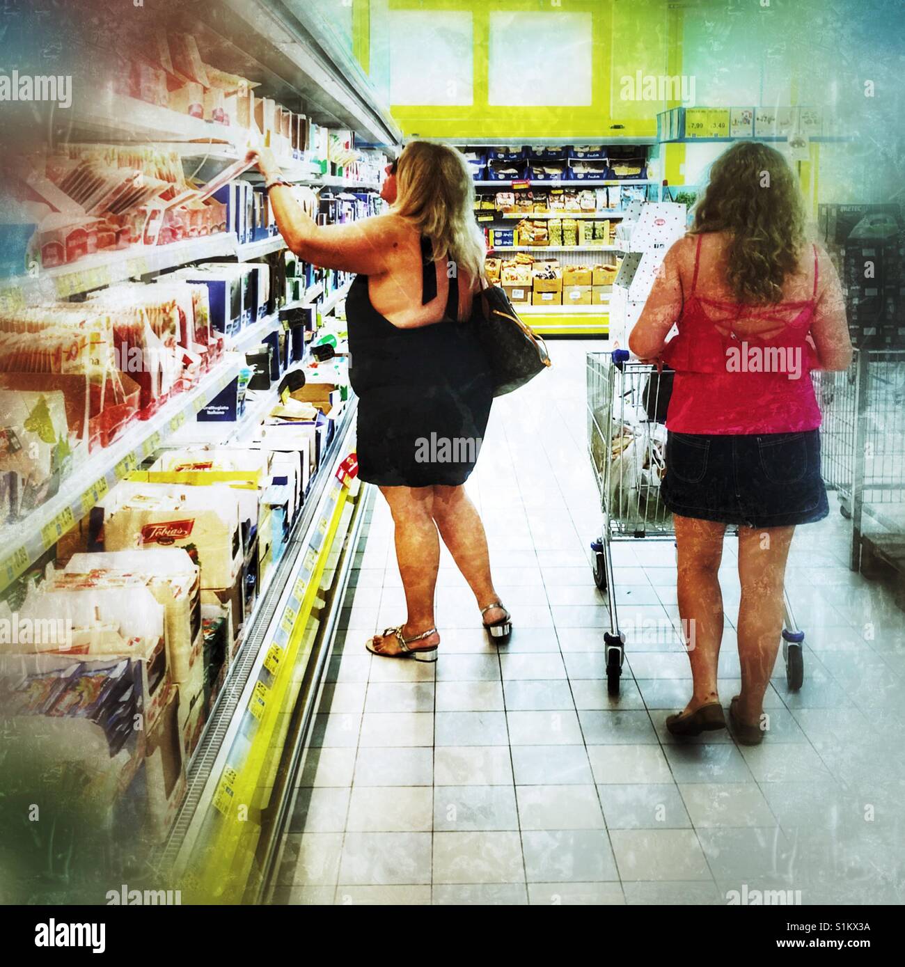 Grassa donne negozi di generi alimentari Foto Stock