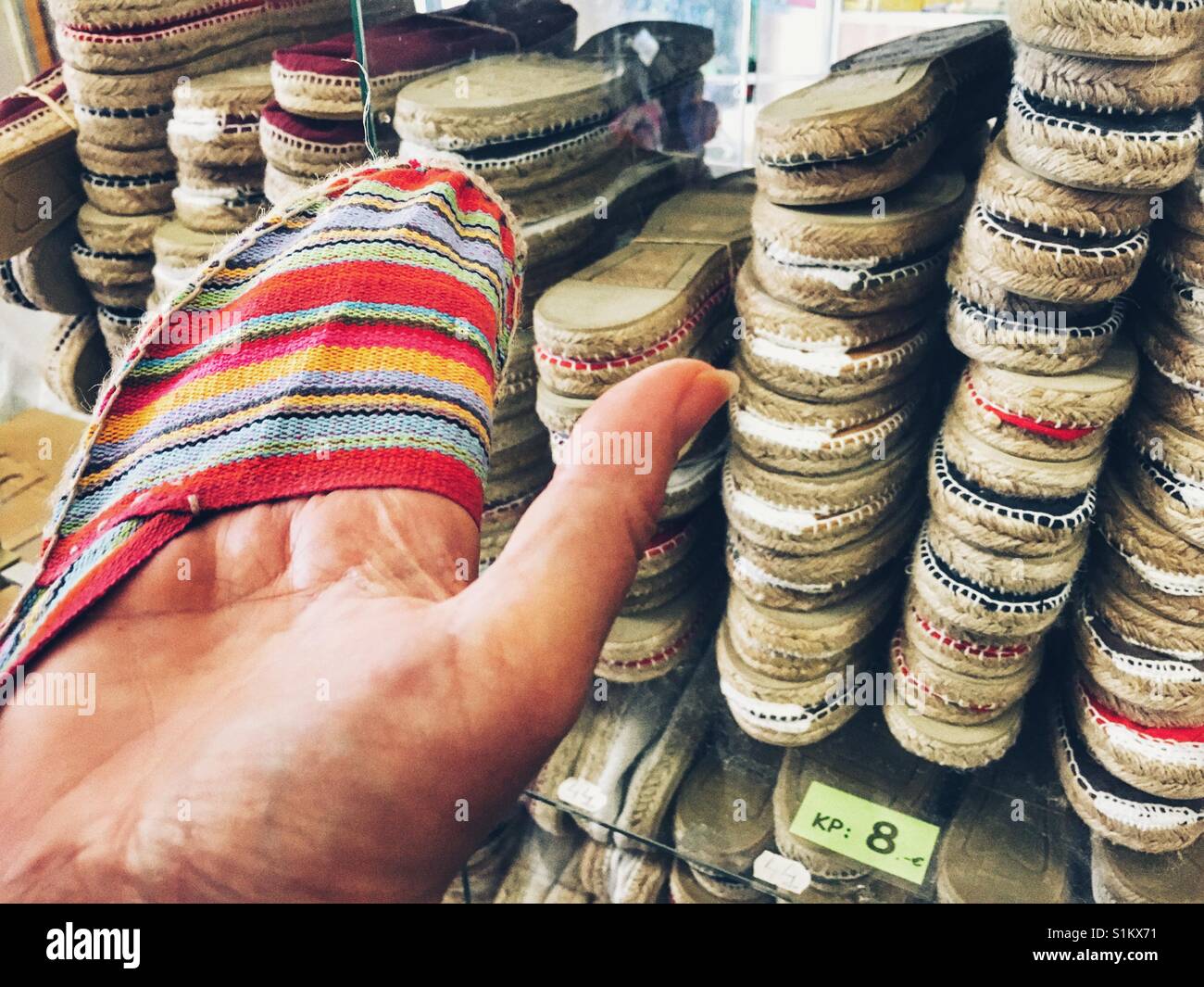Donna che guarda " espadrilles " in spagnolo un negozio di scarpe, close up Foto Stock