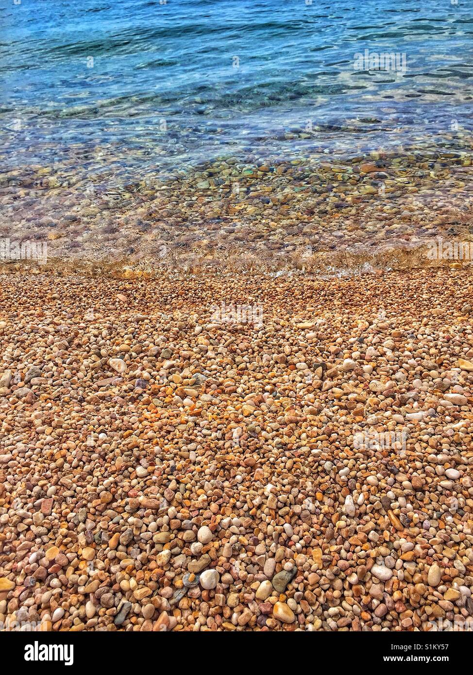 Spiaggia ghiaiosa e delicata onda. Calma pacifica scena. Adatto per uno sfondo. - Immagine stock catturata con smartphone