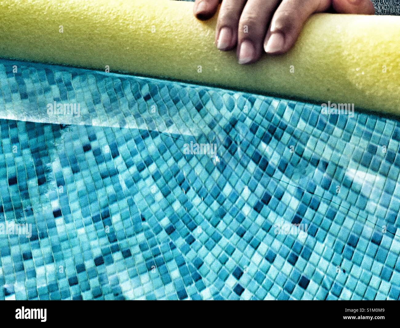 Mano sulla piscina a base di noodle in piscina Foto Stock