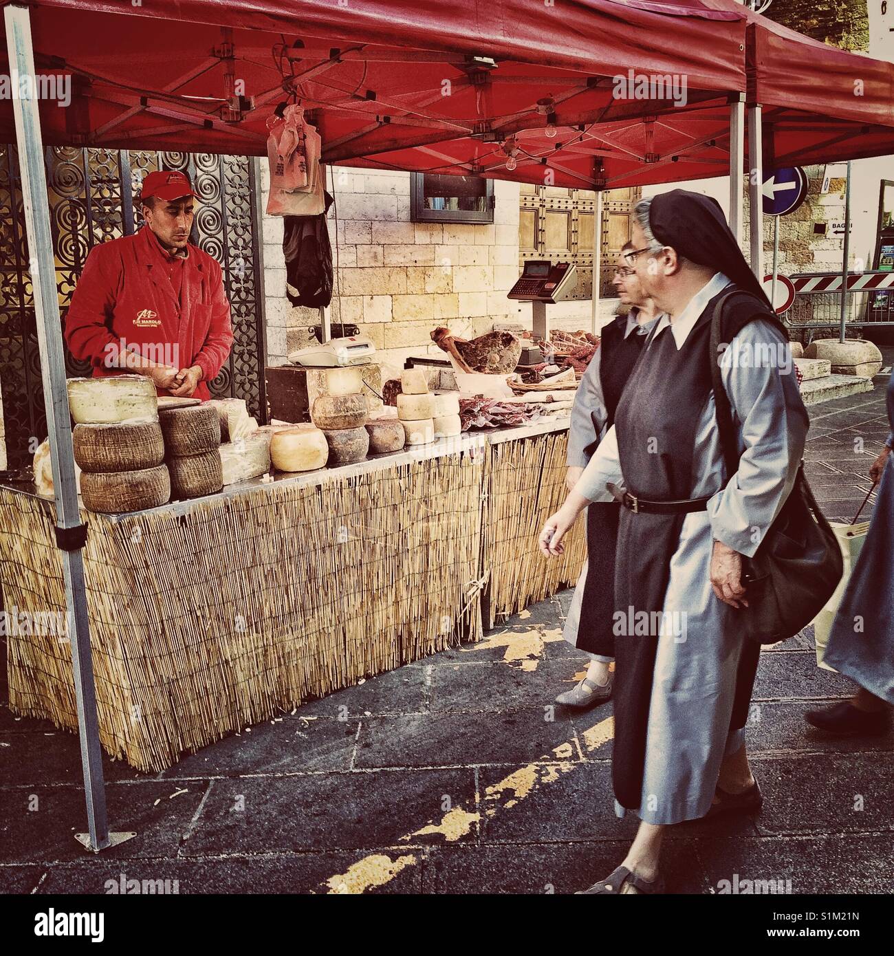 Suore Francescane occhiatura il formaggio al mercato in Assisi, Italia. Foto Stock