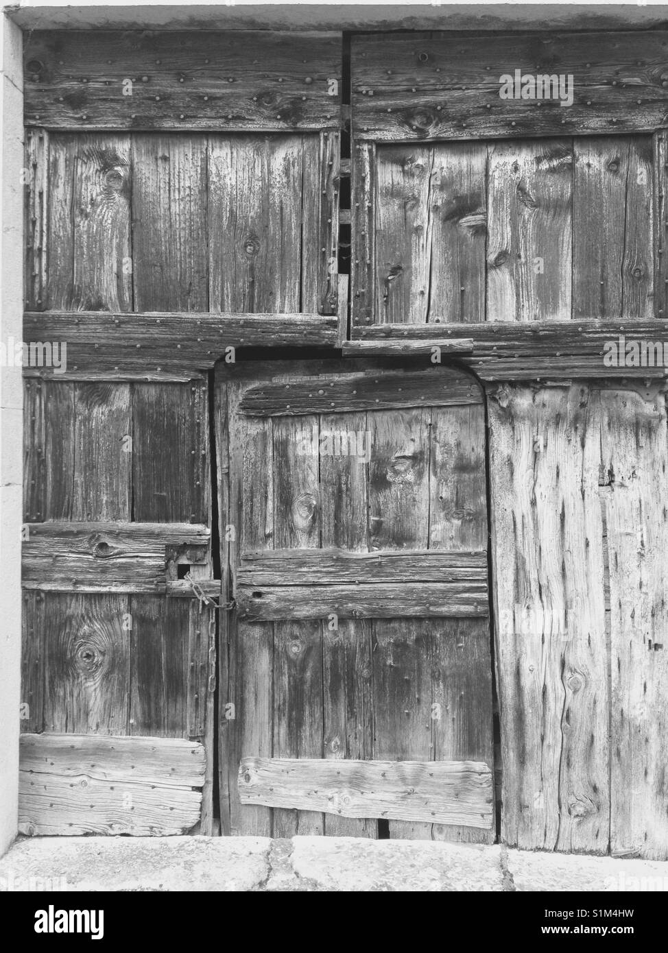 Vecchia fattoria rustica casa / fienile porta composta da sbiadito vecchio legno / legname. In tonal in bianco e nero. Foto Stock