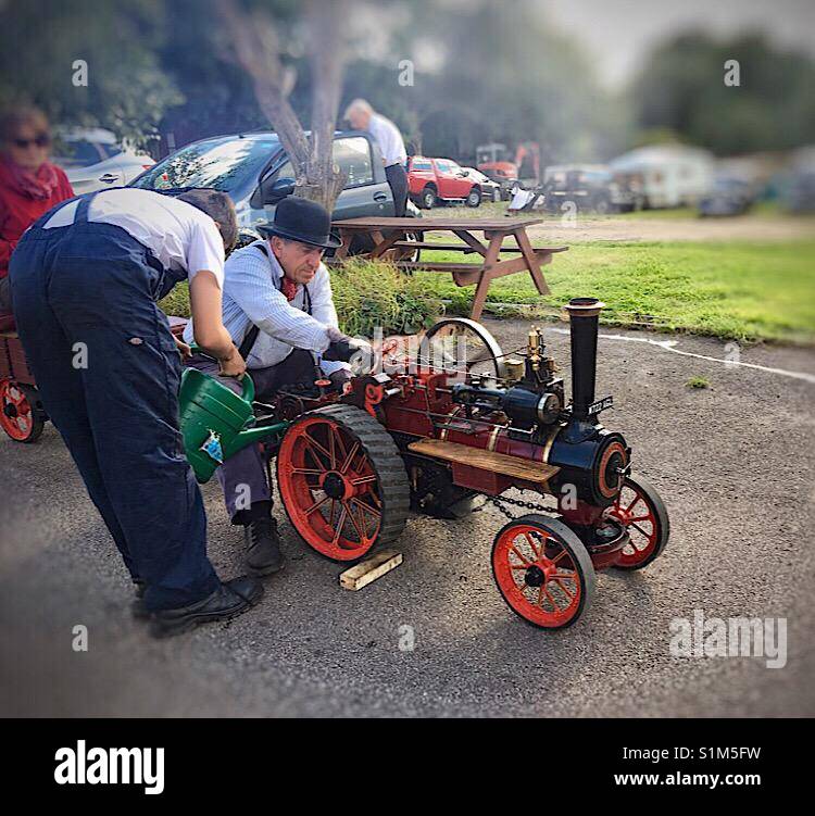 Il Maestro e il suo apprendista tendendo il loro motore di vapore. Foto Stock