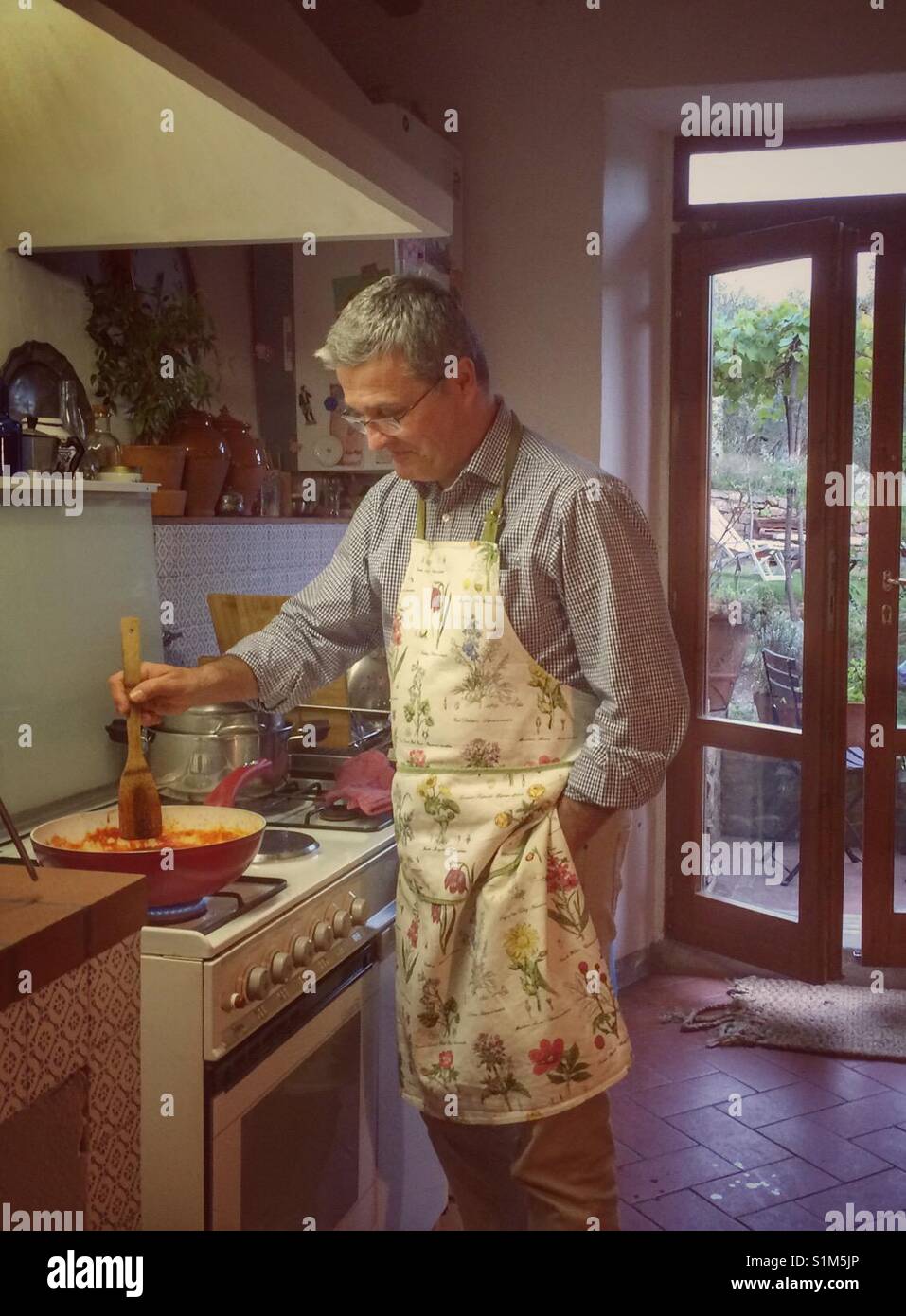 L'uomo una cottura in cucina in Toscana. Foto Stock