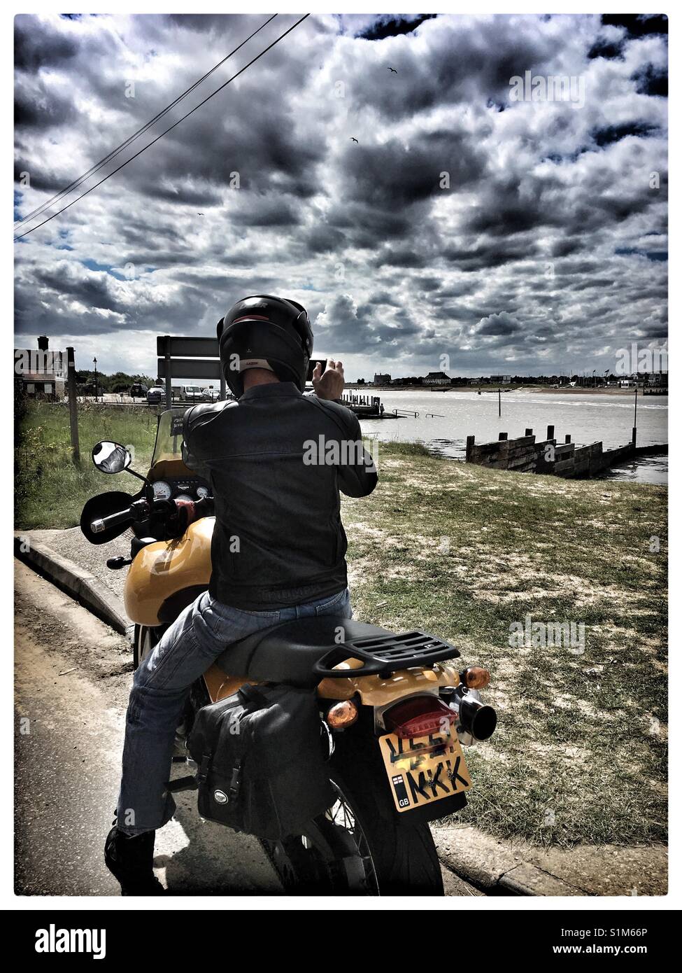 Motociclista prendere una fotografia del vecchio Felixstowe da Bawdsey Quay. Foto Stock