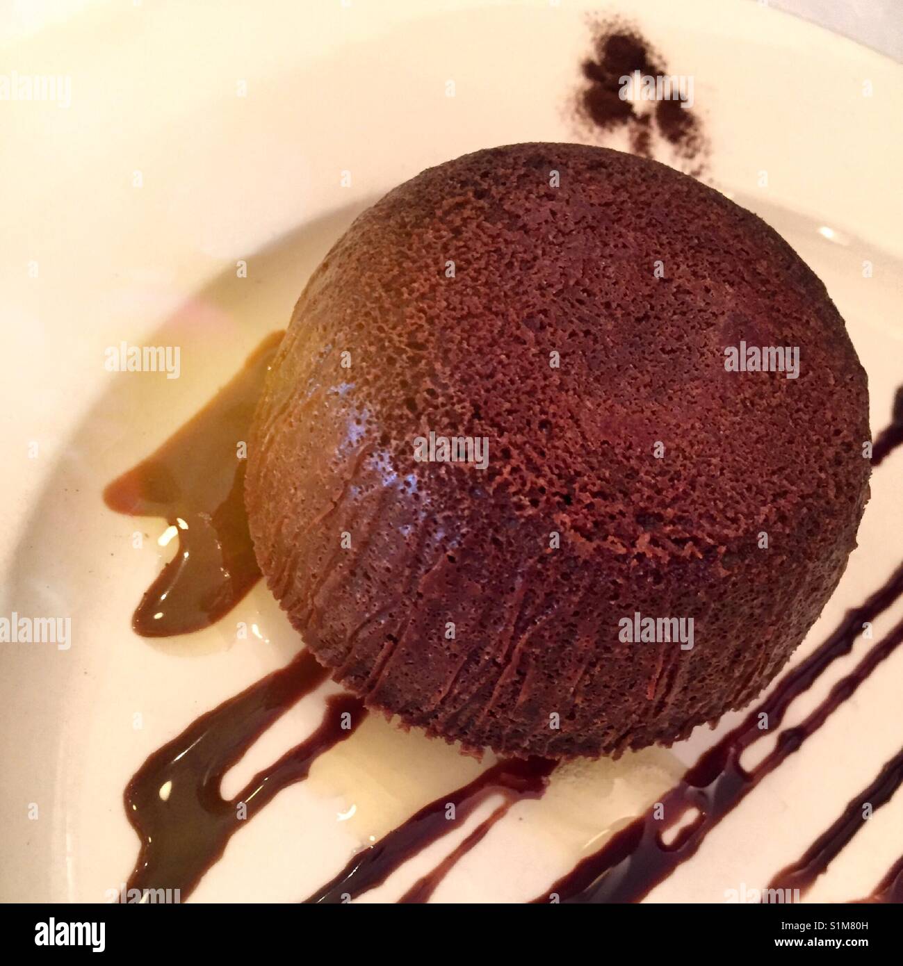 Presentazione gourmet di torta al cioccolato con una spruzzata di sciroppo al cioccolato al ristorante di lusso, New York City, Stati Uniti d'America Foto Stock