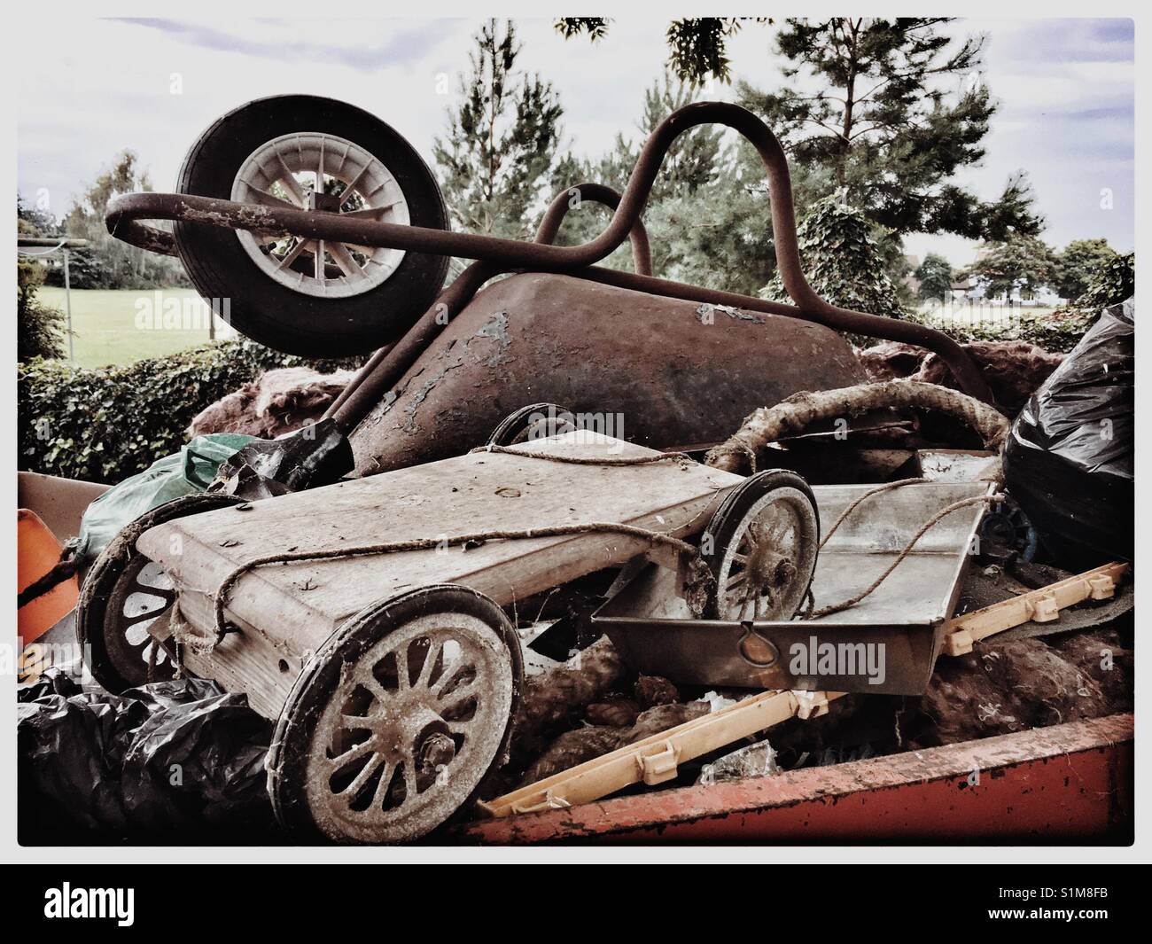 Saltare al di fuori di una casa di gioco contenente una ruota barrow e vintage go cart. Foto Stock