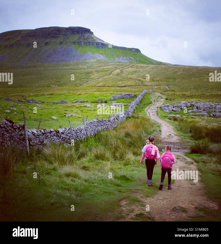 Due ragazze si avvicinano Pen Y Gand Hill nel Yorkshire Dales National Park. - Immagine stock catturata con smartphone