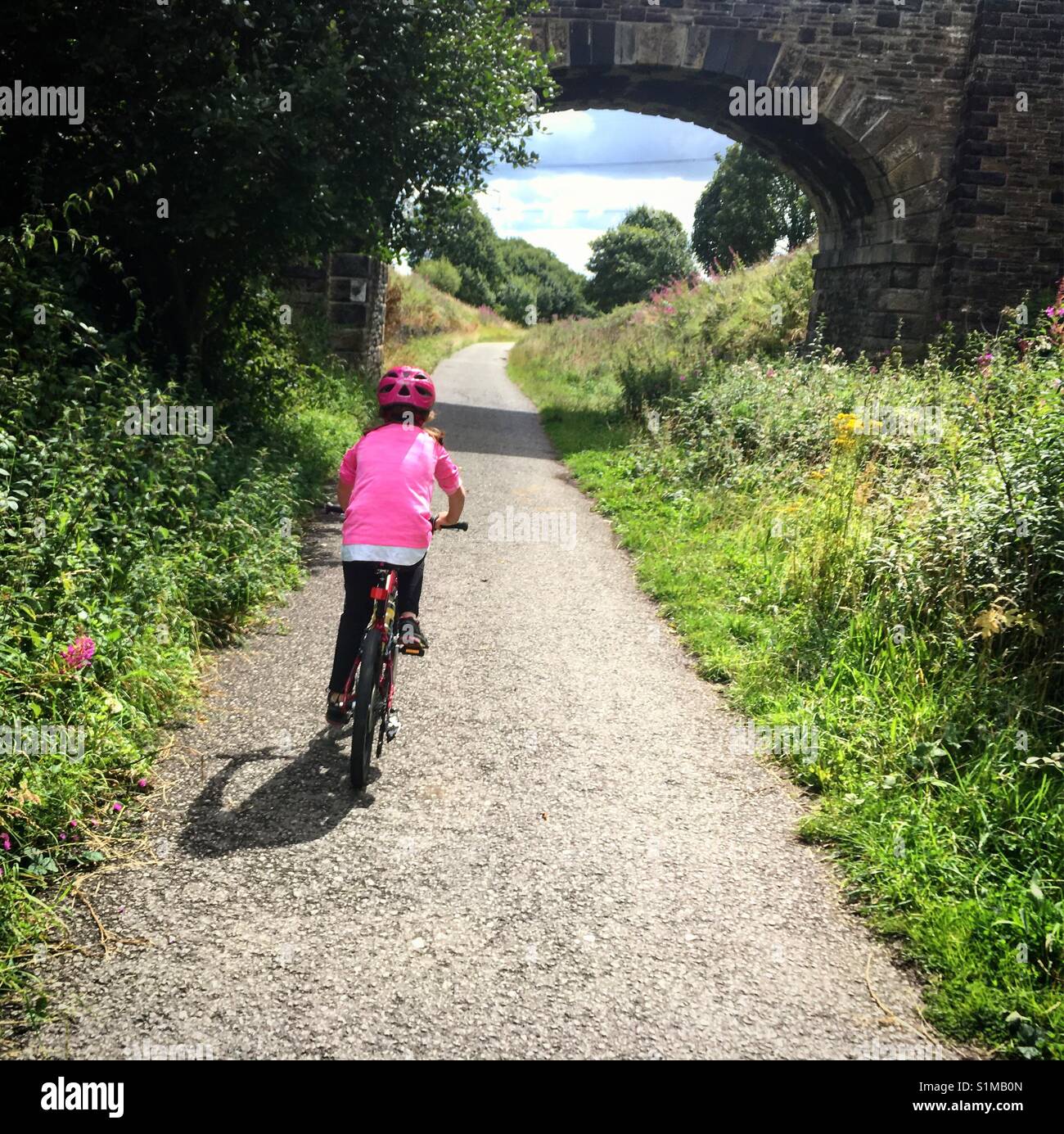 Ragazza in sella a una moto sulla grande ferrovia settentrionale trail a Thornton nei pressi di Bradford, Regno Unito Foto Stock