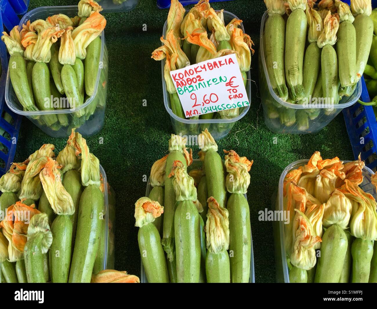 Zucchine con fiori venduti presso il vivace mercato di Salonicco. - Immagine stock catturata con smartphone