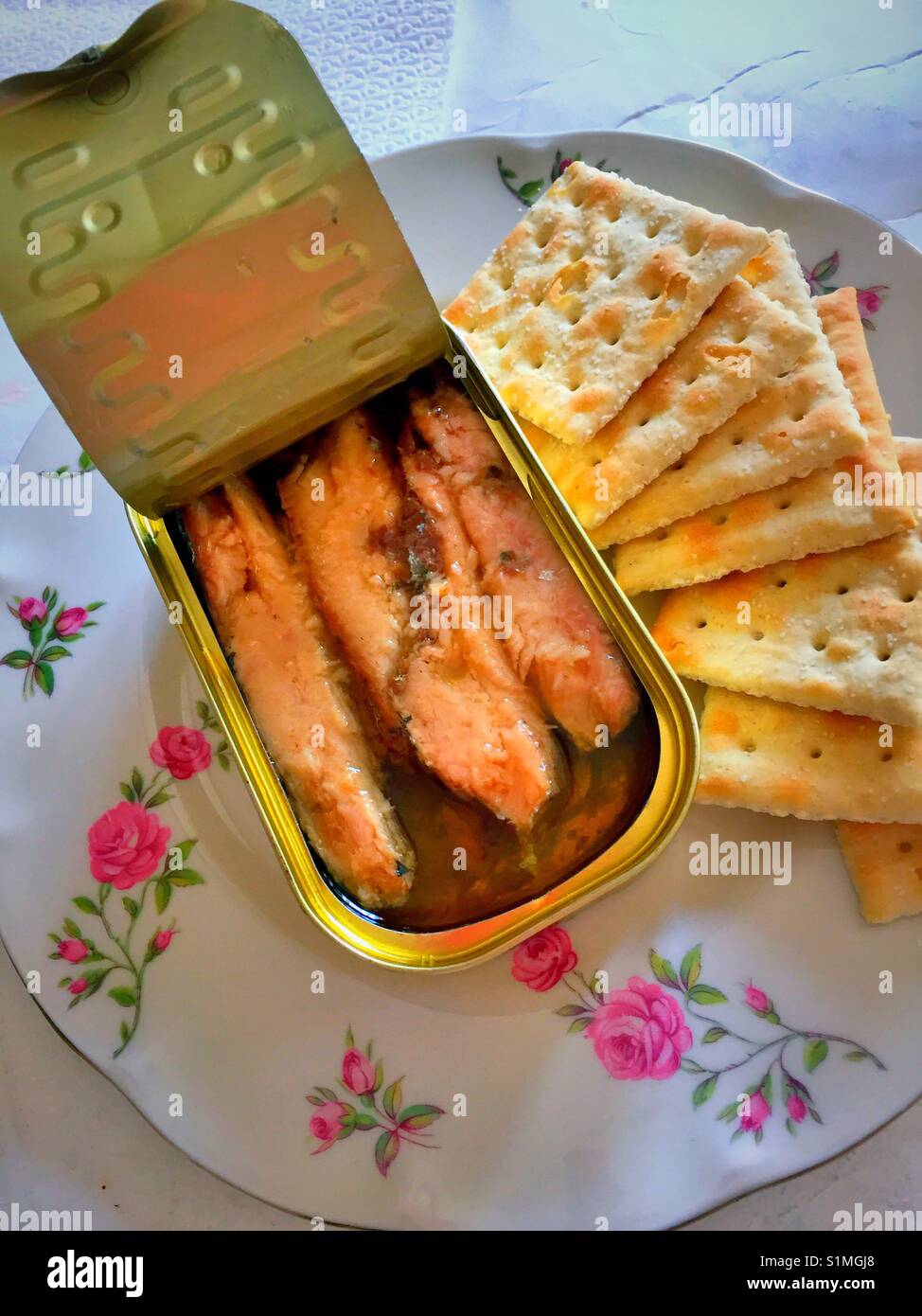 Aprire lo stagno di pelle di sardine e saltine cracker su un modello di rose piastra Cina, STATI UNITI D'AMERICA Foto Stock