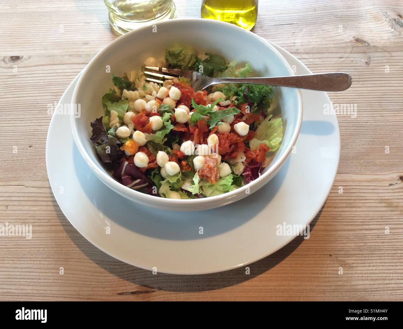 Appetitosi insalata di pasta, fusilli, pomodori, mozzarella servita nella ciotola bianco Foto Stock