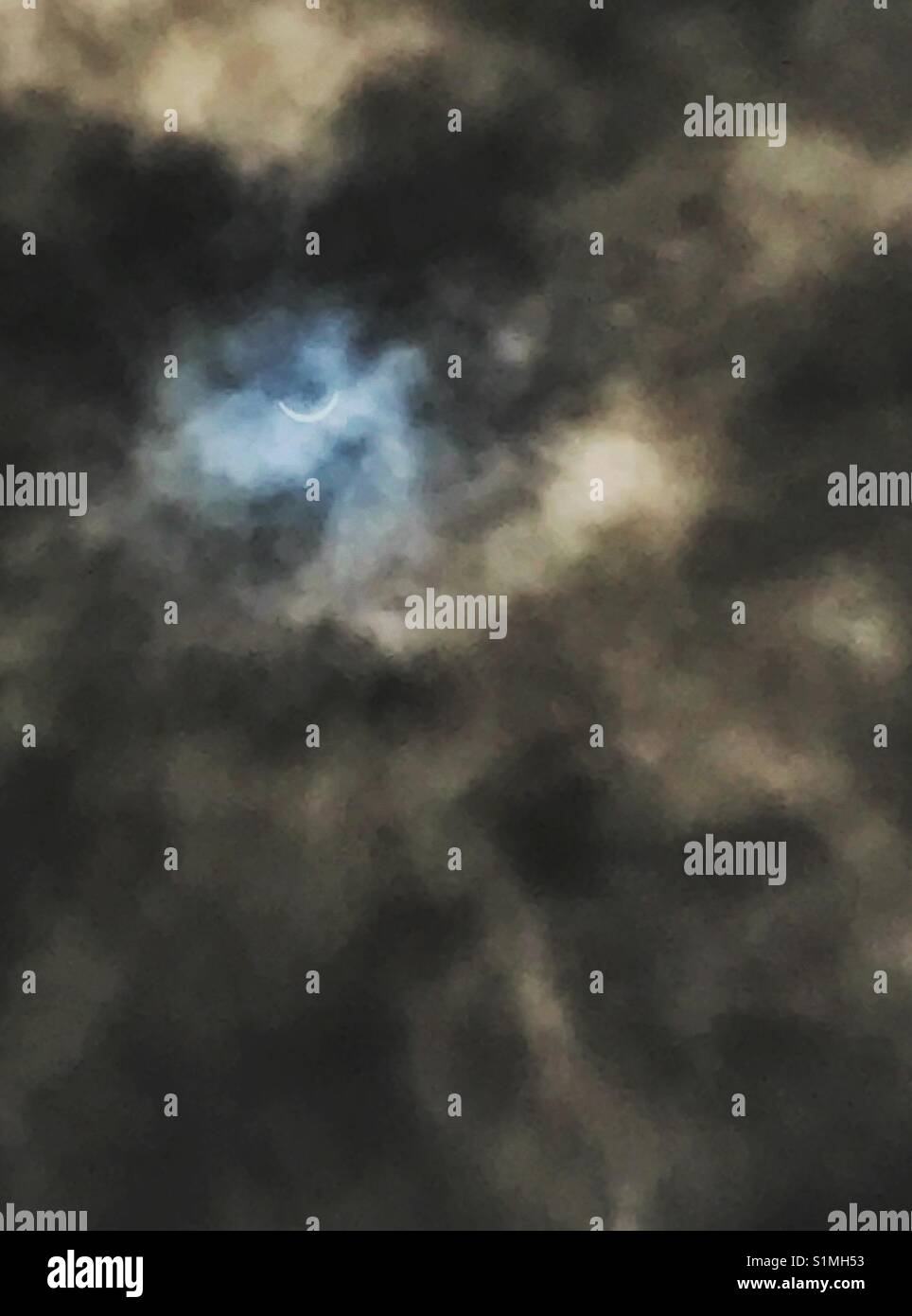 Eclissi solare visibile attraverso sopito nuvole scure, Jacksonville, Florida, 21 agosto 2017 - Immagine stock catturata con smartphone