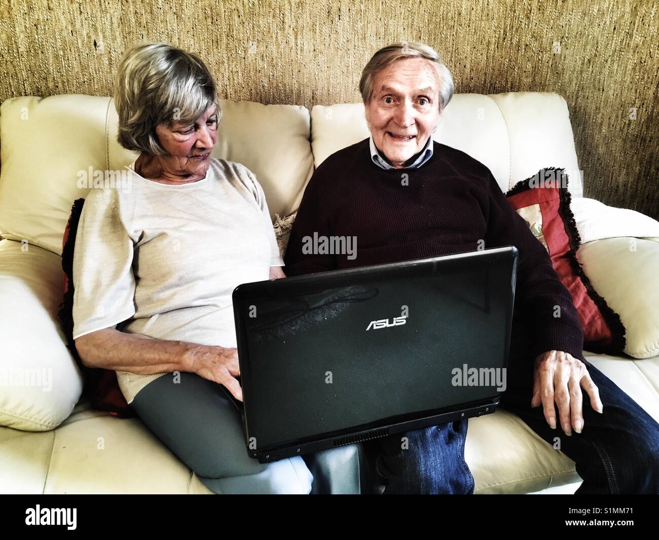 Coppia di anziani utilizzando il computer portatile - Immagine stock catturata con smartphone