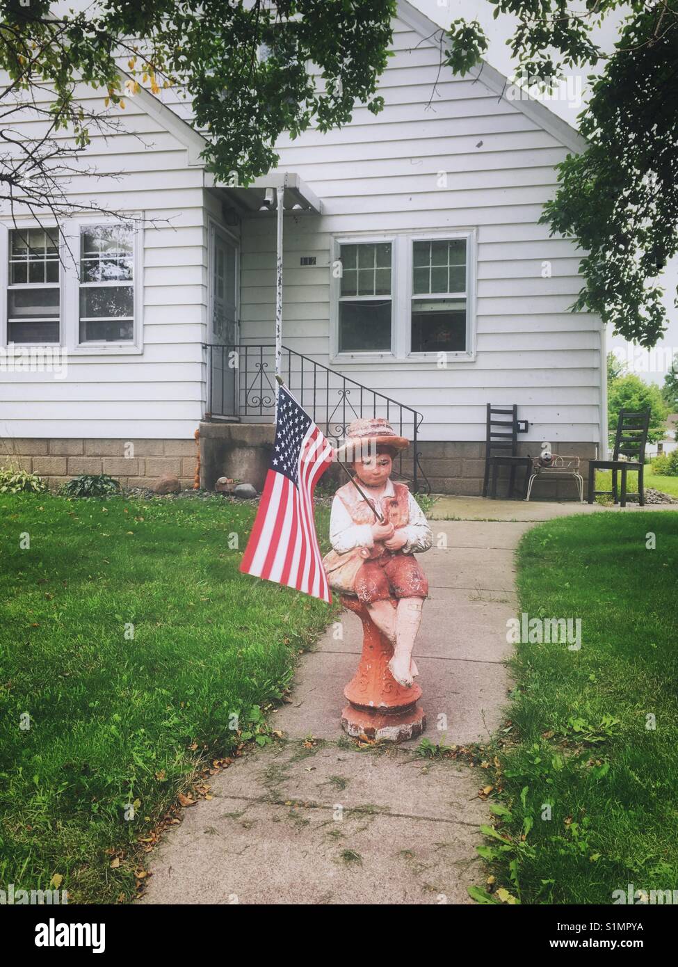 Giardino atatue di un ragazzo con noi bandiera - Immagine stock catturata con smartphone