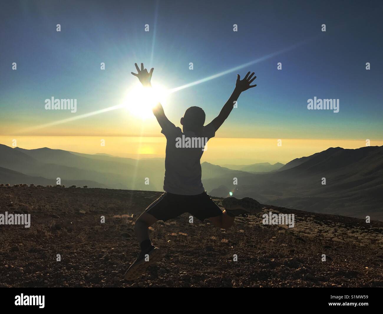 Silhouette di un capretto jumping salta allegramente sul top del Nero Qorna montagna - Libano Foto Stock