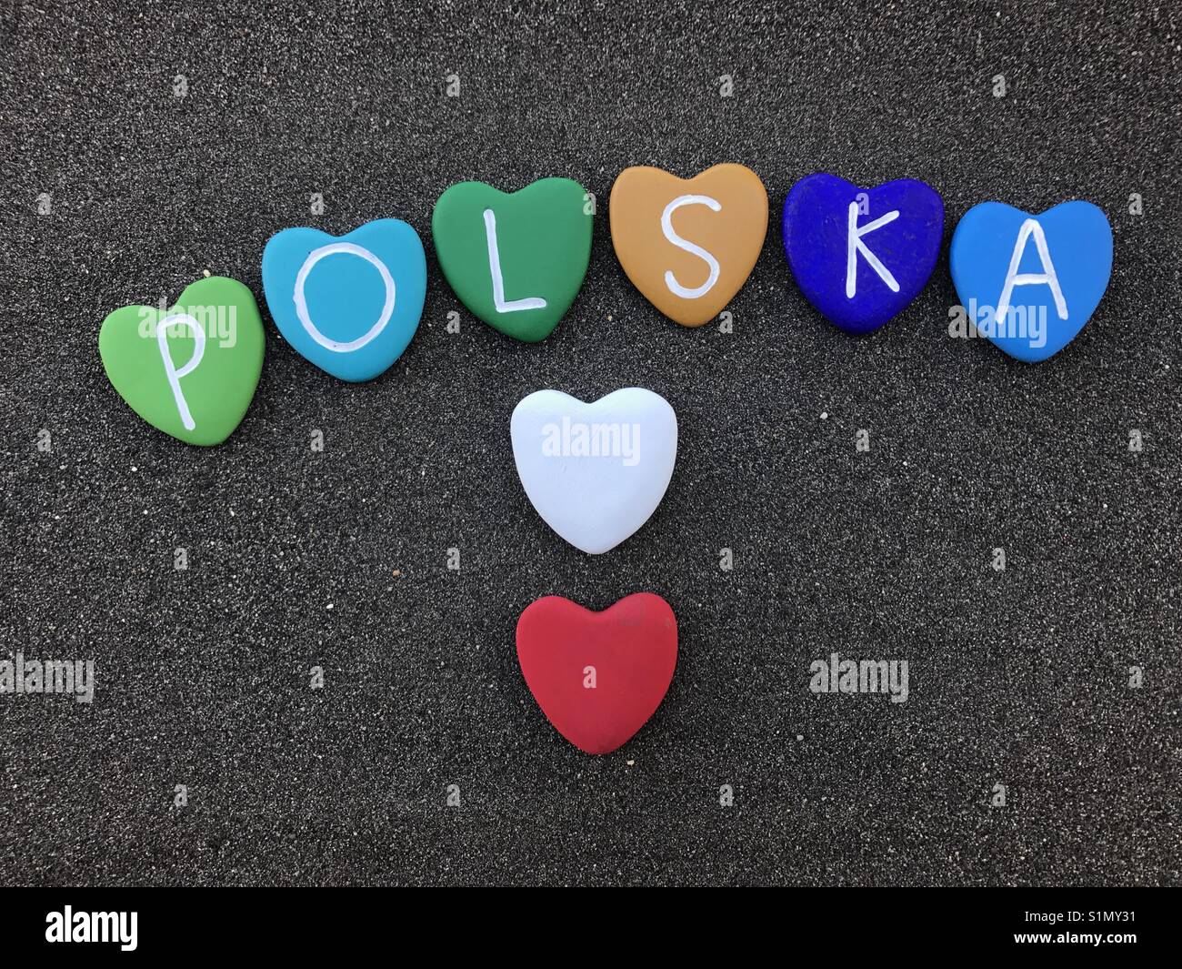 Polska nome paese con cuore colorato pietre su sabbia nera vulcanica Foto Stock