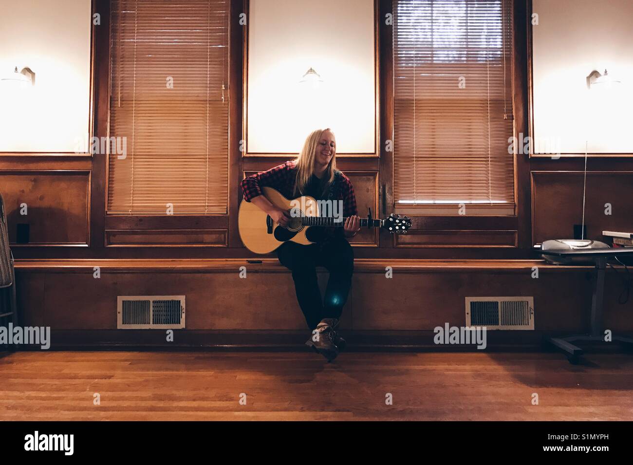 Appena una ragazza sul banco di lavoro con una chitarra. Foto Stock