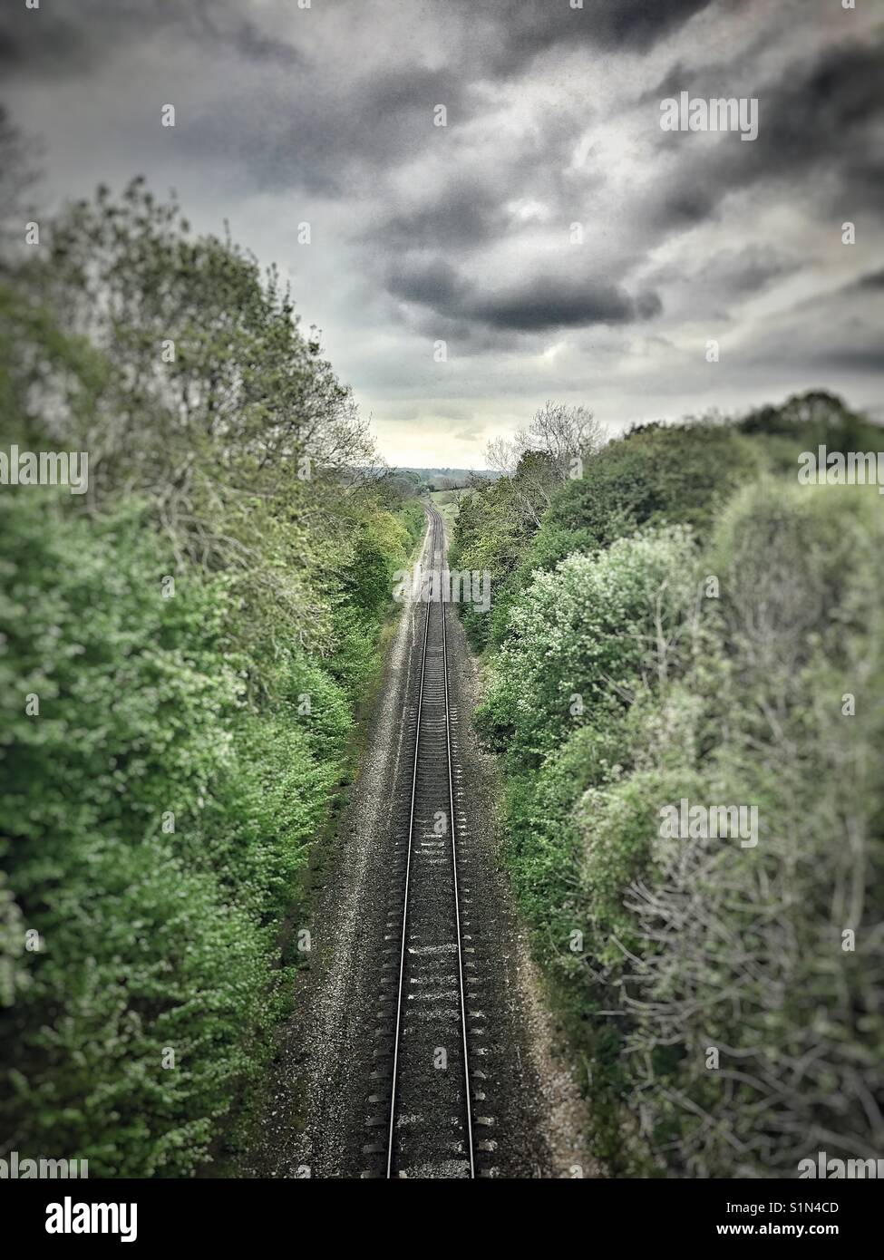 Un treno lungo la via che si protende nella distanza Foto Stock