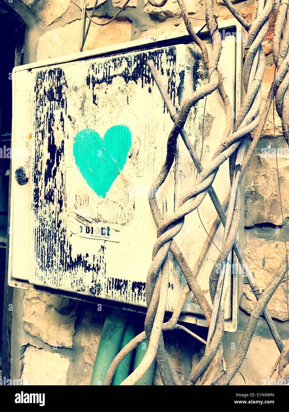 Un solitario cuore turchese disegnati su una scatola elettrica sulla strada. Foto Stock