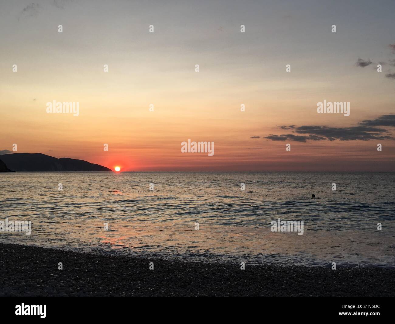 Tramonto sulla bellissima spiaggia di Myrtos su Cefalonia in mare Ionio in Grecia Foto Stock