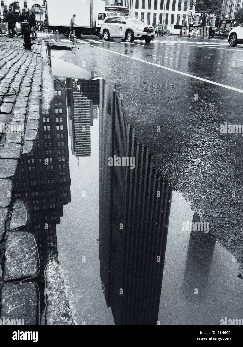 Una pozza d'acqua con le riflessioni del New York dello skyline della citta' dopo il temporale. Foto Stock