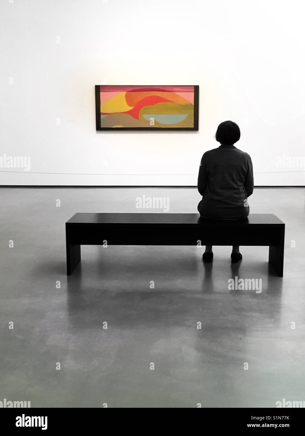 Una donna sat guardando un dipinto in Hepworth Wakefield - Immagine stock catturata con smartphone