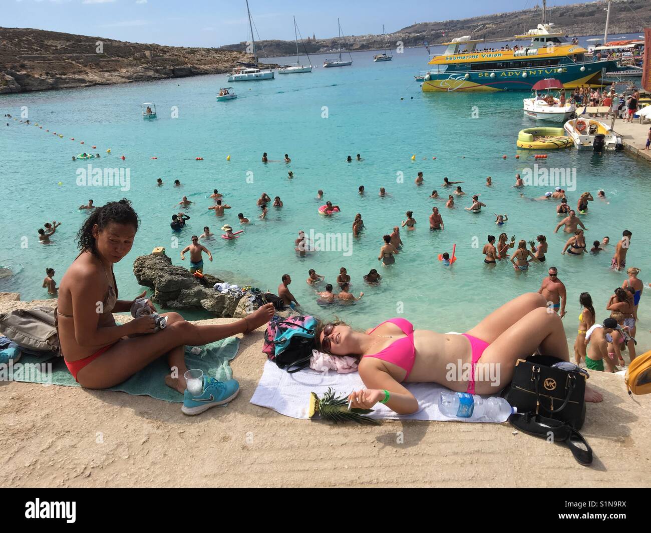 Lucertole da mare e nuotatori a Laguna Blu a Comino e Malta Foto Stock