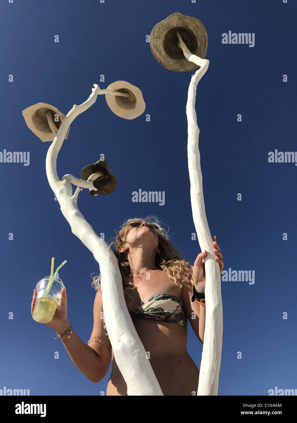 Ragazza di bere un cocktail sotto un albero, mentre godendo il sole - Immagine stock catturata con smartphone