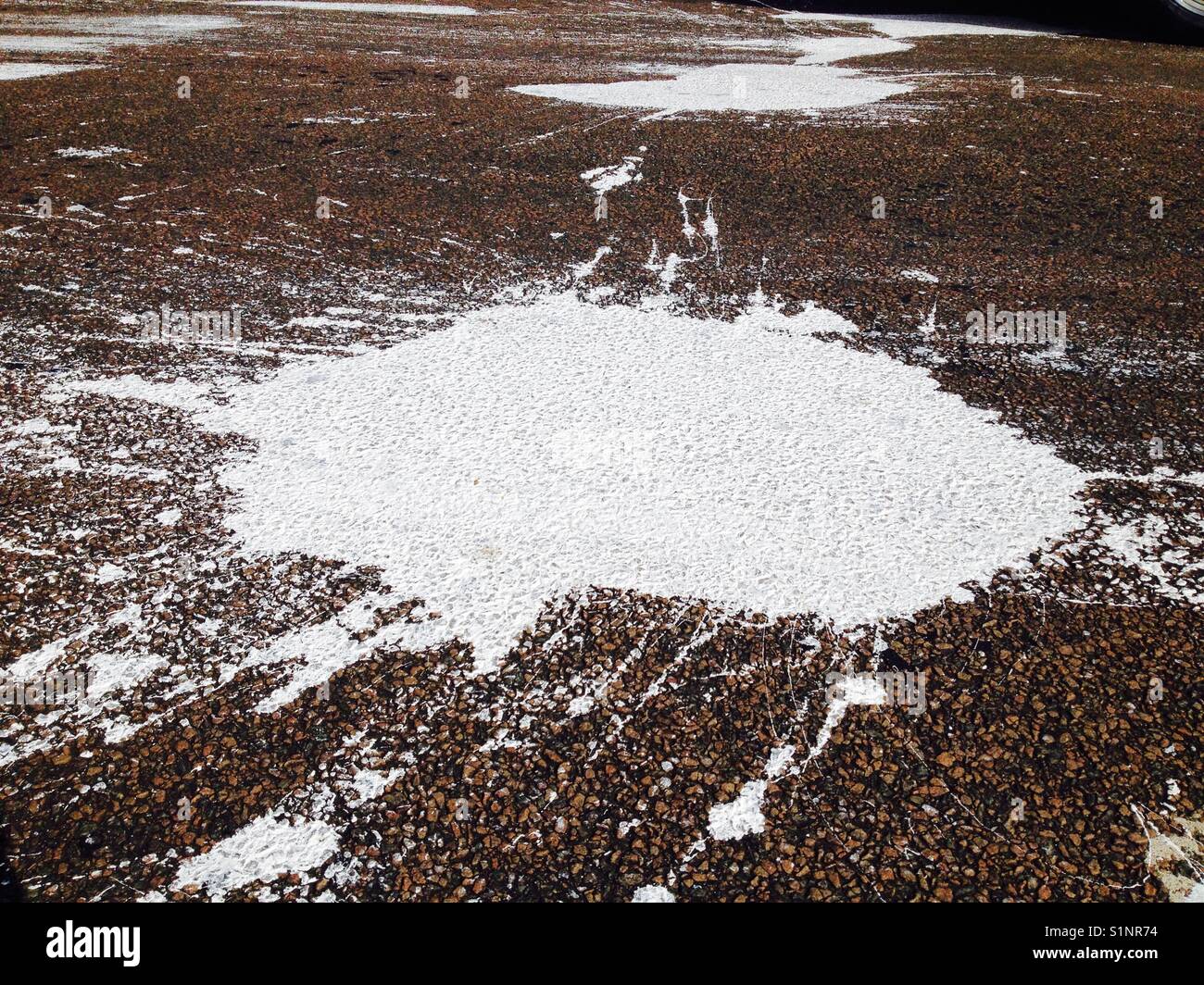 Eventuali fuoriuscite di / fuoriuscita di spruzzi di vernice opener sulla strada asfaltata / superficie di strada. Foto Stock