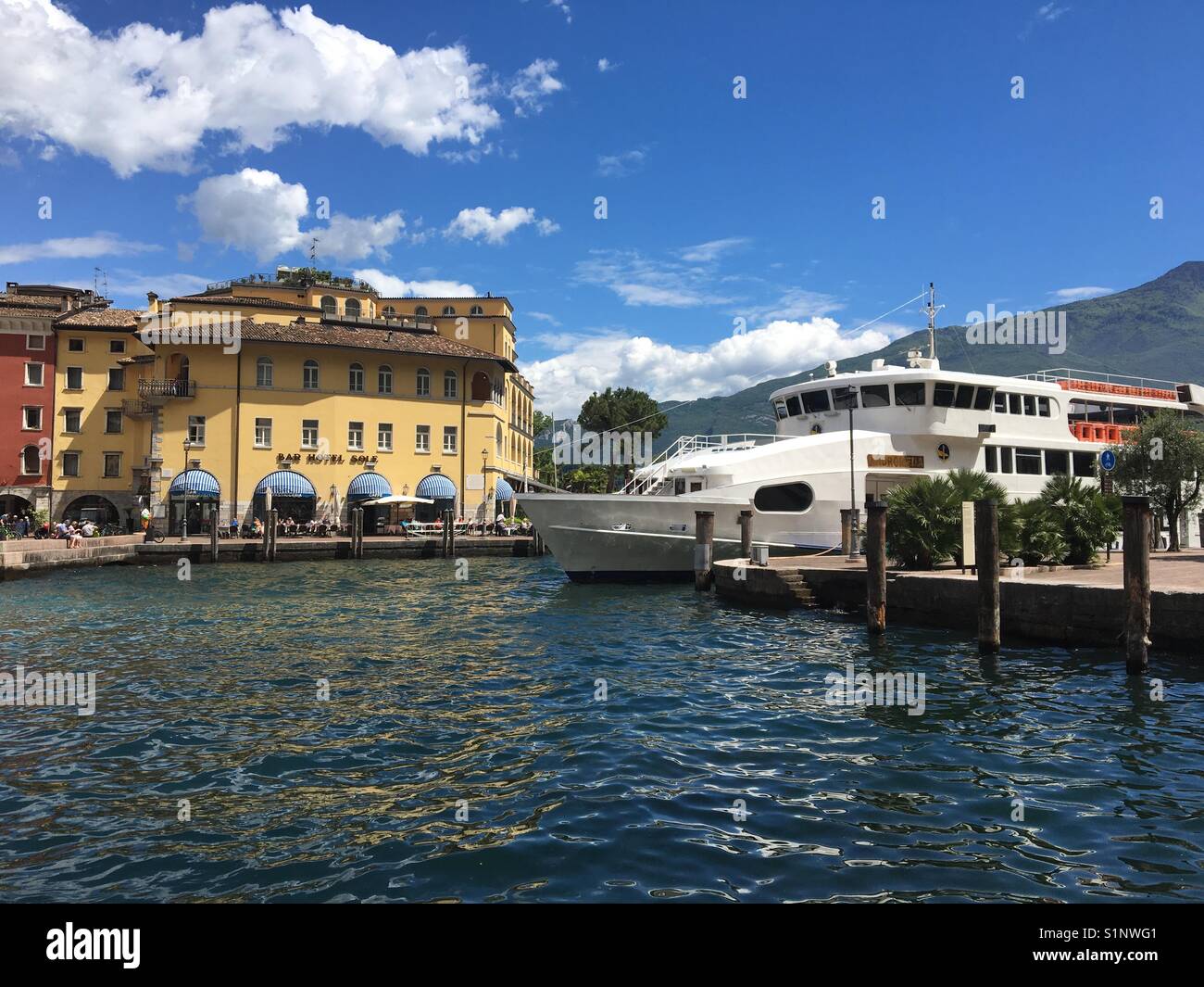 Il piccolo porto di Riva del Garda, Italia, con un traghetto ormeggiata in banchina Foto Stock