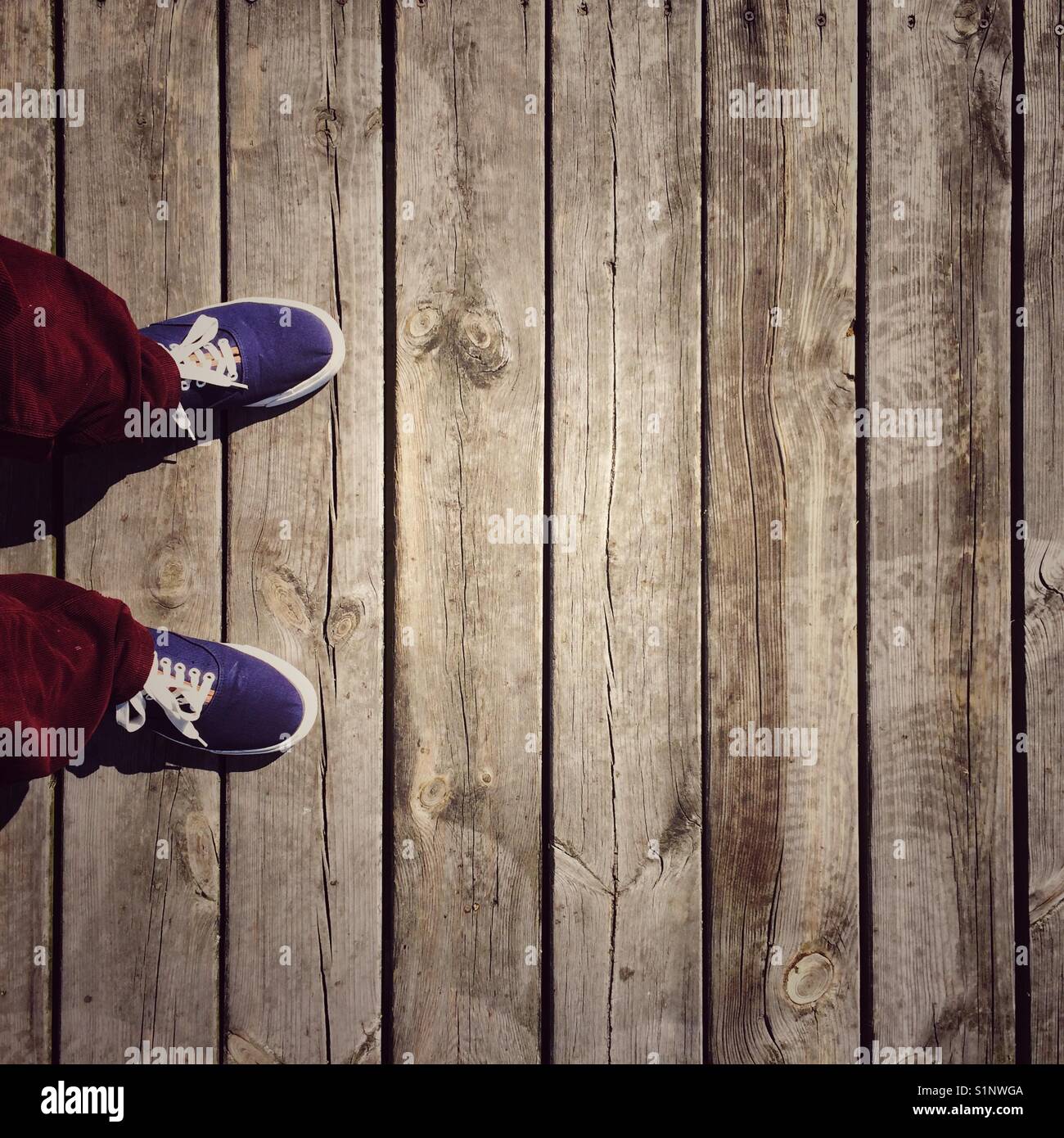 Persona con i piedi sul marciapiede in legno - Immagine stock catturata con smartphone