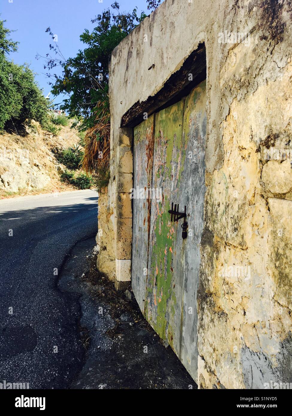 La vecchia porta e la parete e la strada nei pressi di Kaligata sull'isola di Cefalonia in Grecia Foto Stock