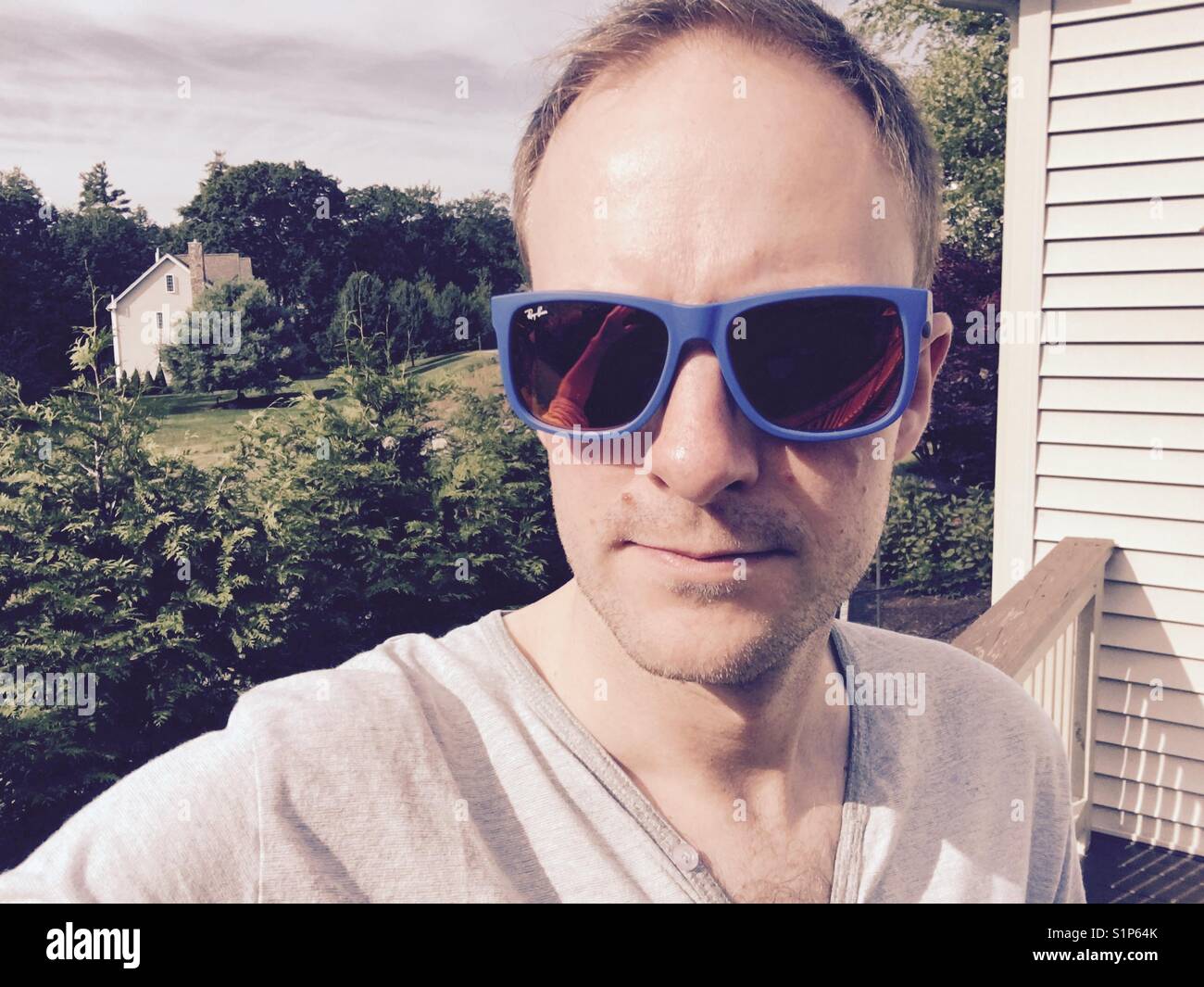 Uomo che indossa Rayban occhiali da sole con lenti riflettenti e telai blu , STATI UNITI Foto Stock