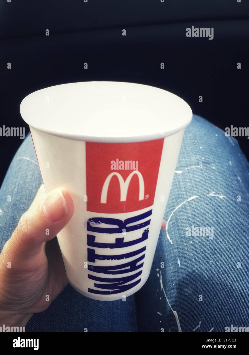 Bicchiere di carta con il McDonald logo in una mano - Immagine stock catturata con smartphone