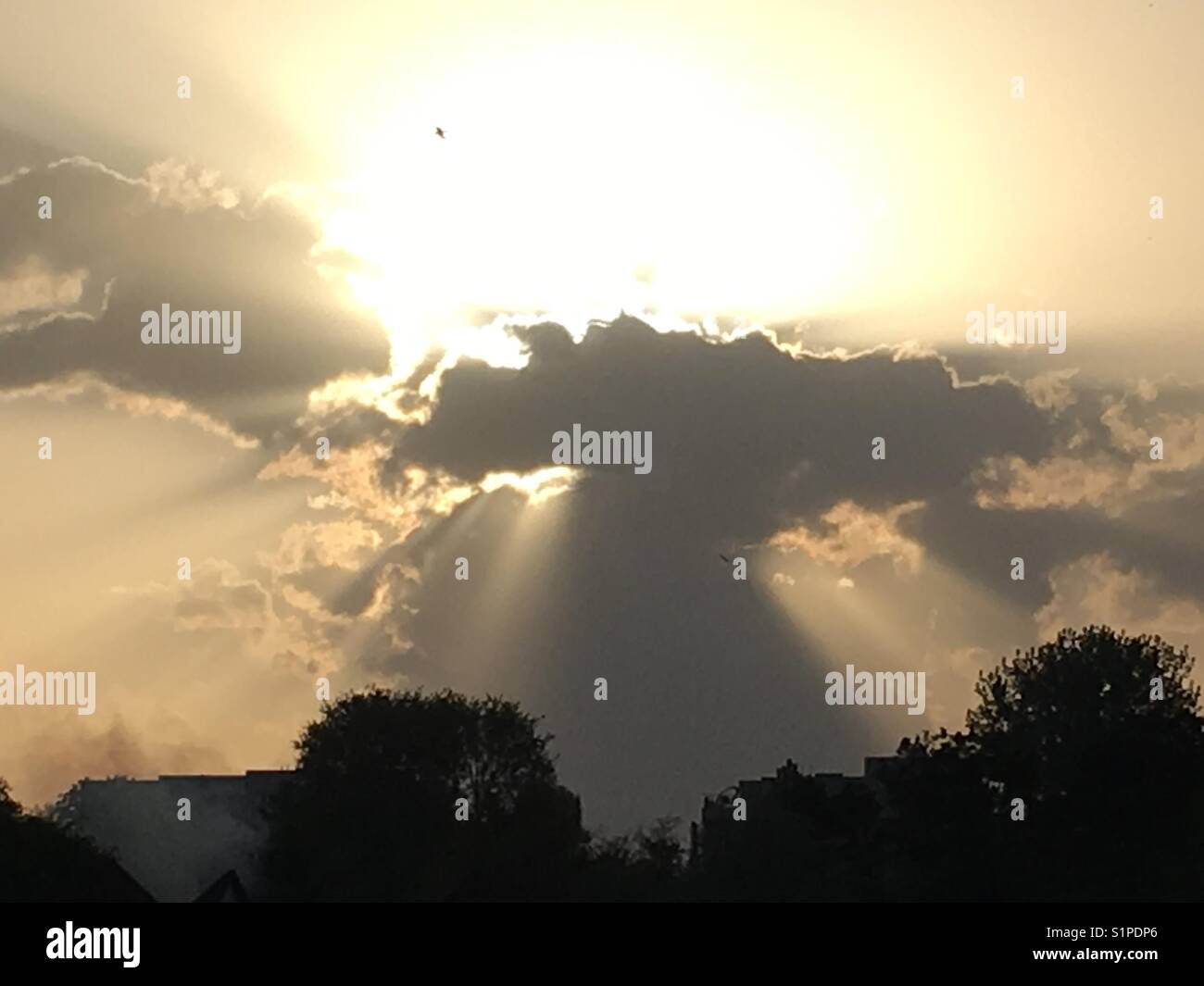 Il sole che tramonta dietro il cloud Foto Stock