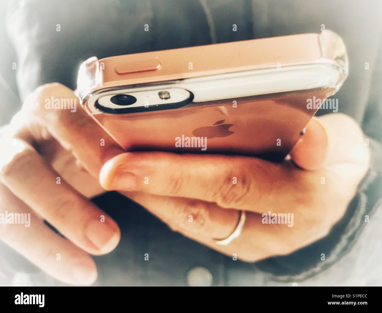 La tecnologia wireless. Donna che utilizza un iPhone. La sezione centrale, close-up del telefono in mani. Foto Stock