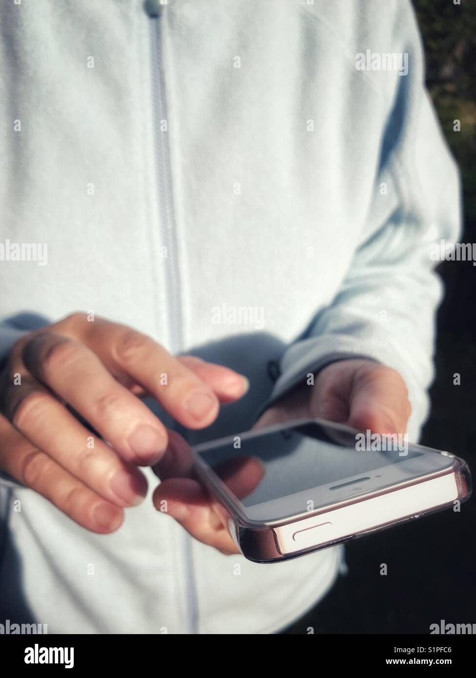 Donna che utilizza uno smartphone all'aperto Foto Stock