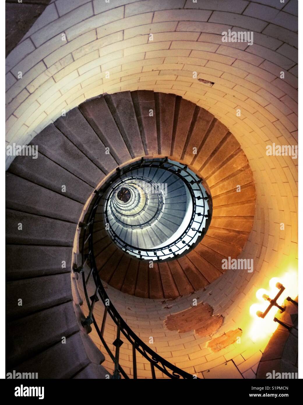 Scala a spirale all'interno del programma Phare d'Eckmuhl Lighthouse in Bretagna nord ovest della Francia. - Immagine stock catturata con smartphone