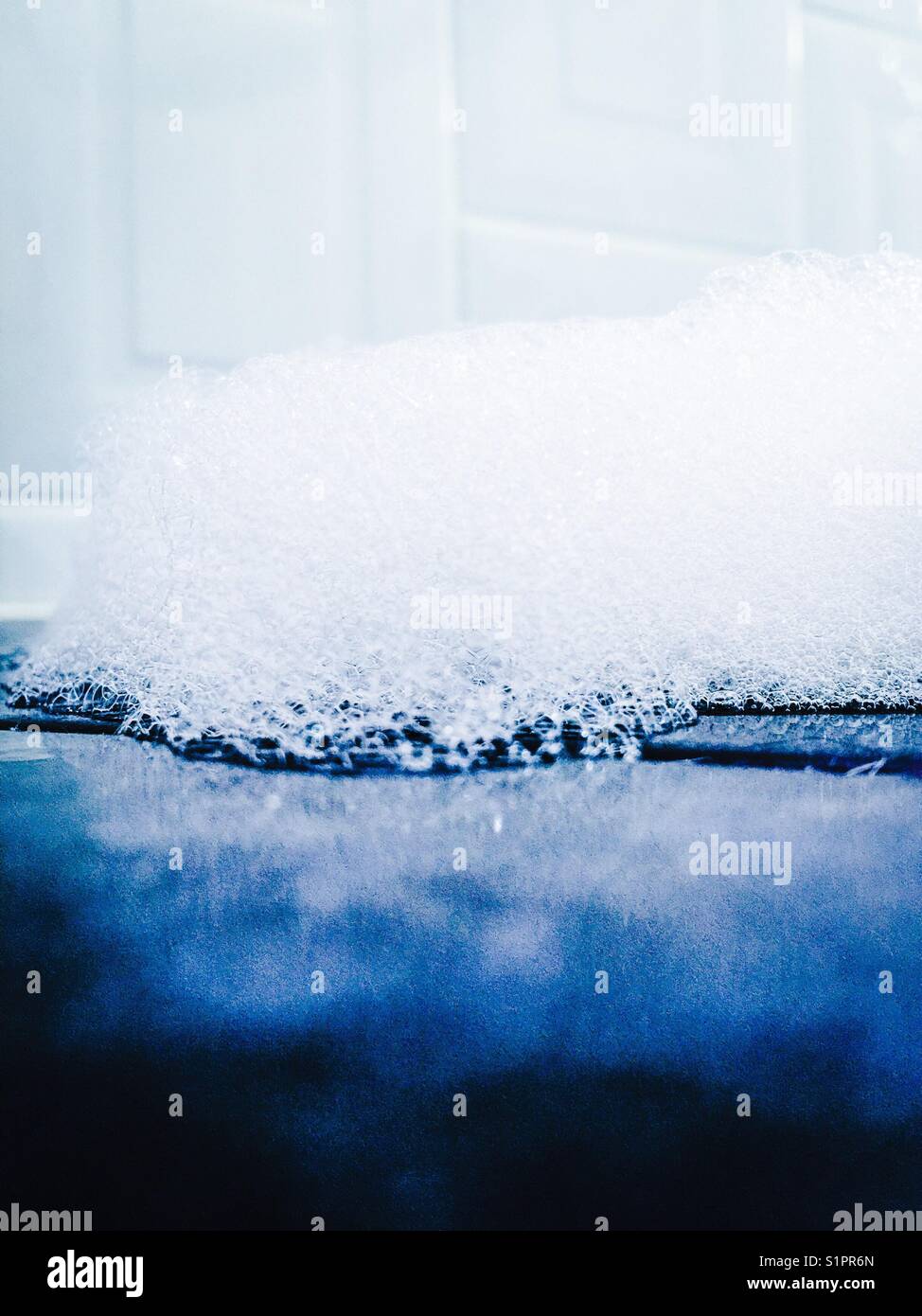 Bolle su piastrelle scure del bagno con piastrelle bianche sullo sfondo - Immagine stock catturata con smartphone