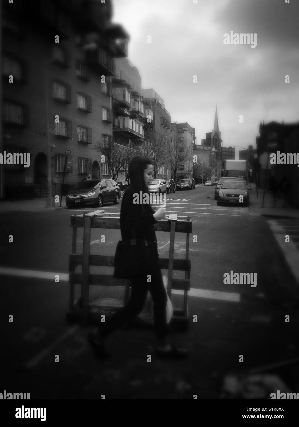Giovane donna attraversando la strada in sud Williamsburg, Brooklyn Foto Stock