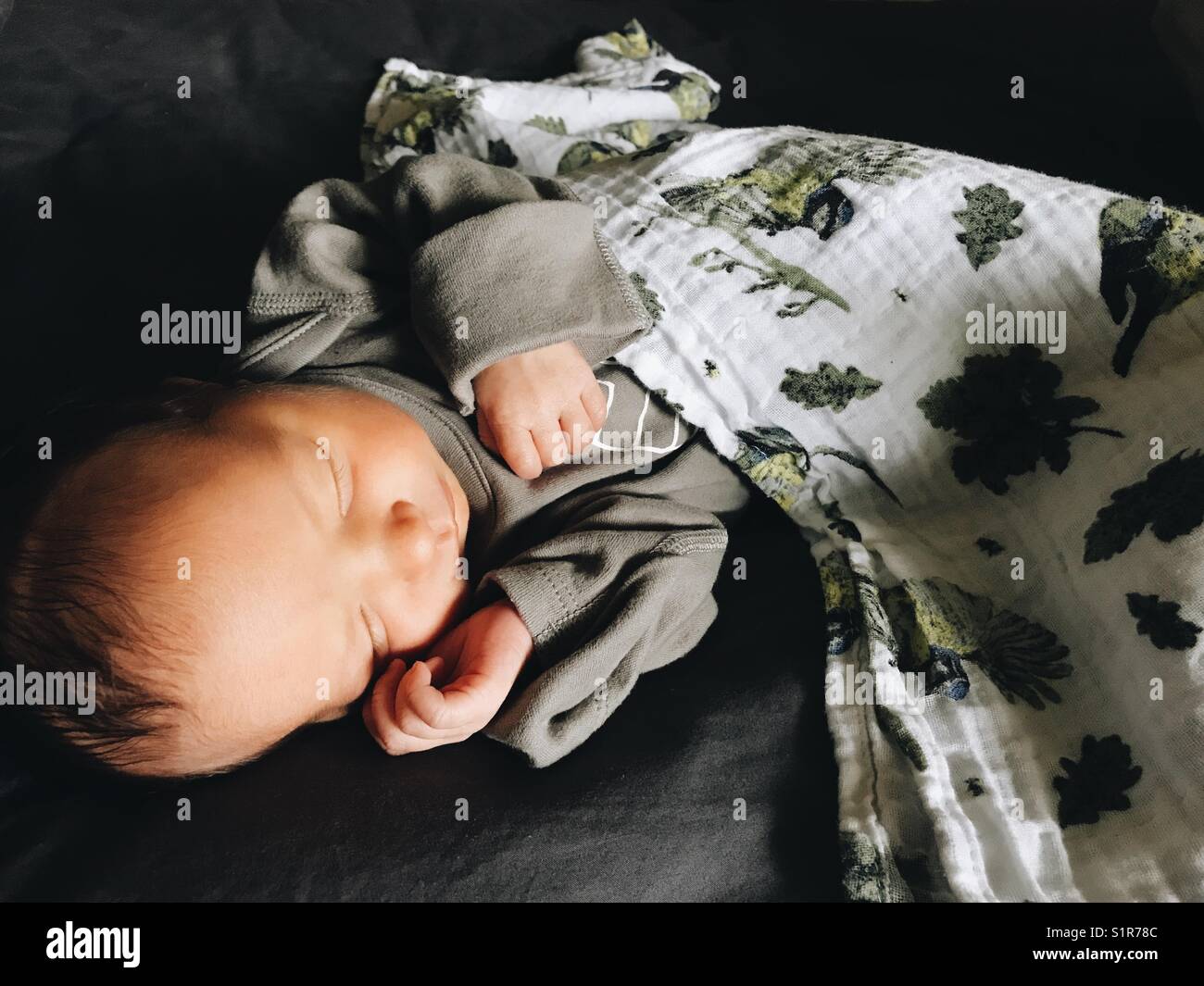 Un neonato addormentato illuminato dalla luce naturale. - Immagine stock catturata con smartphone