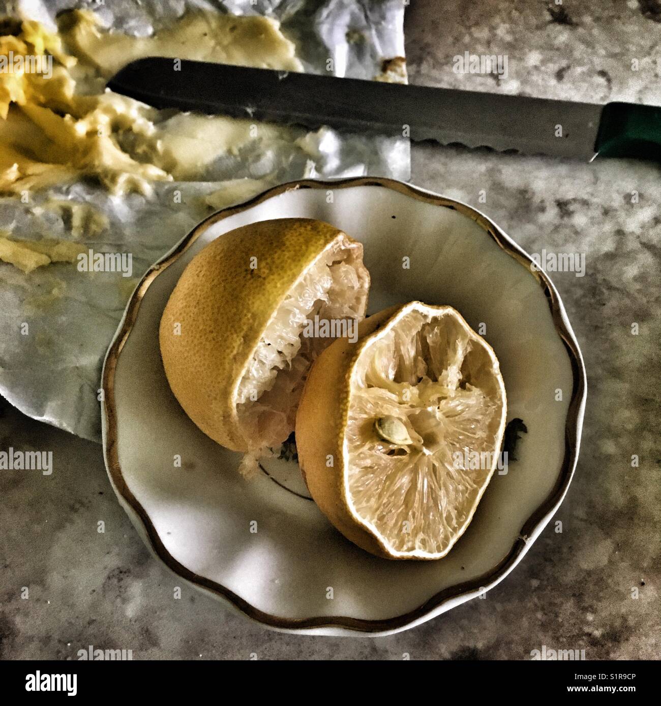 Ancora vita su un tavolo con limoni, burro e coltello Foto Stock
