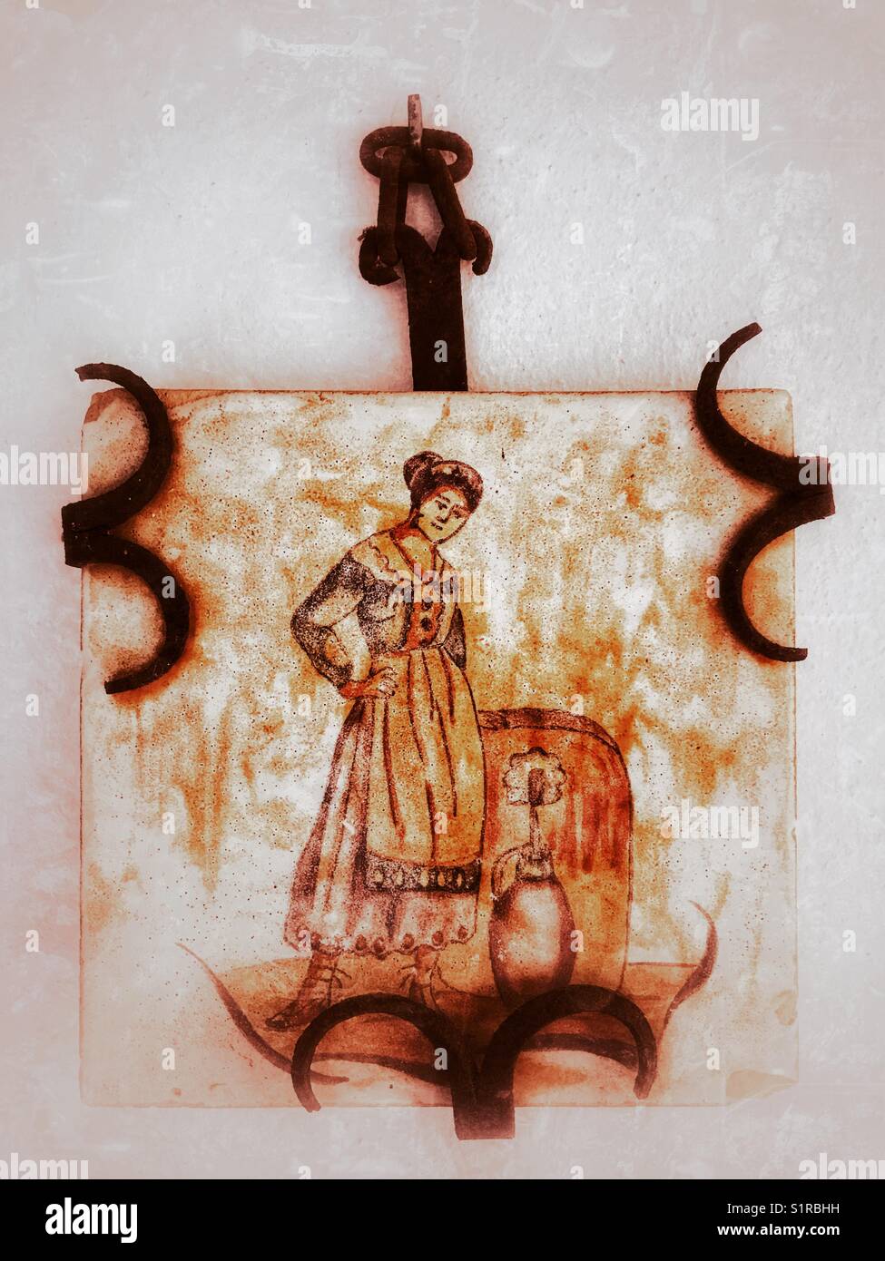 Antiquariato e dipinti a mano spagnolo tile parete montata in ferro battuto di clip e usato come una decorazione murale Foto Stock