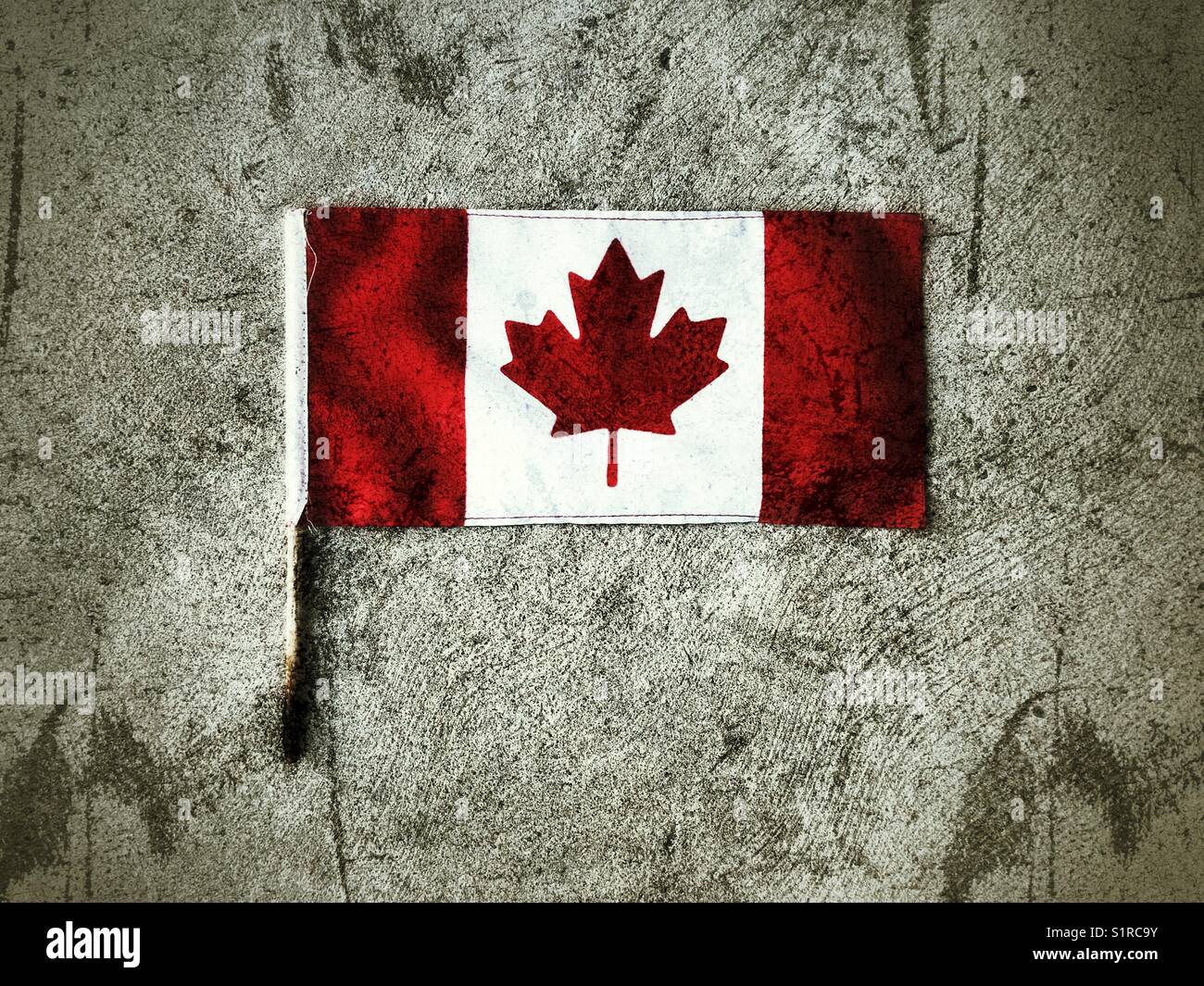 Piccola bandiera del Canada adagiata su cemento Foto Stock