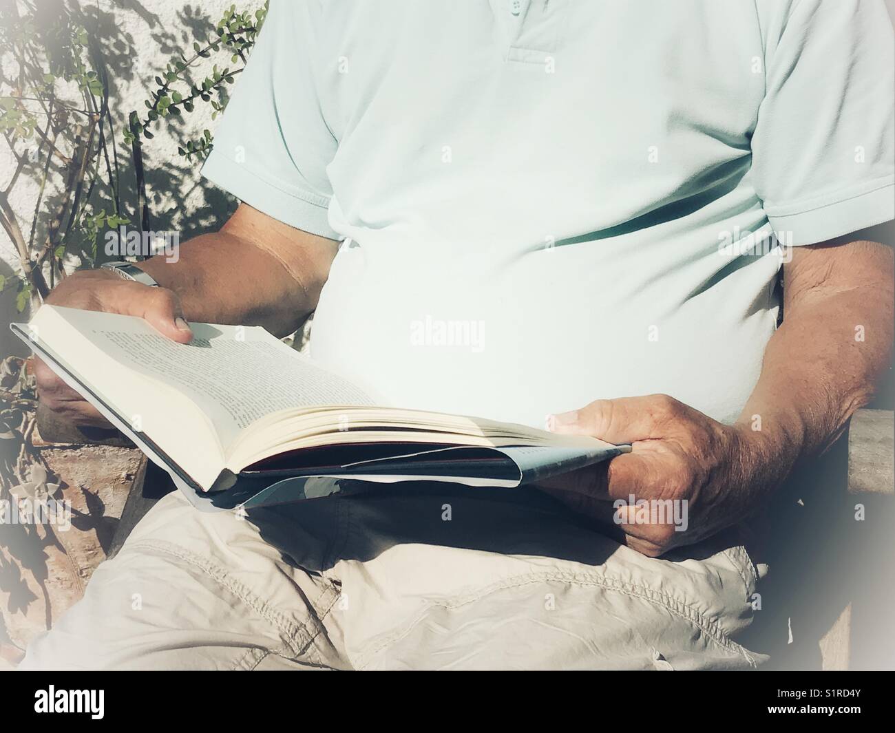 Uomo che legge un libro all'aperto Foto Stock