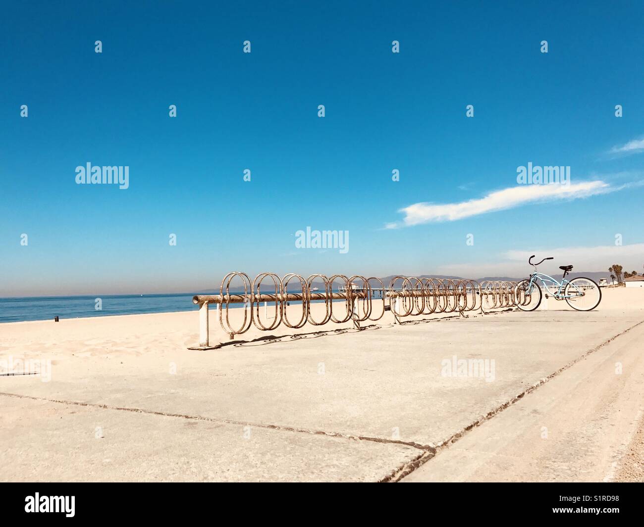 Una bici blu parcheggiata in un portabiciclette in spiaggia. Manhattan Beach, California USA. Foto Stock